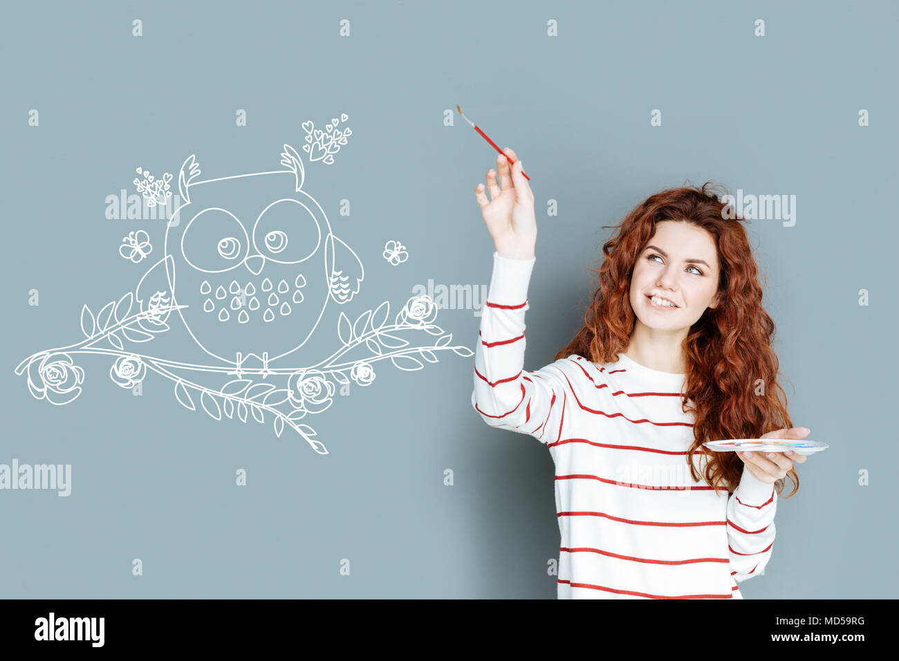 I giovani designer sorridente durante il disegno di una graziosa owl Foto Stock
