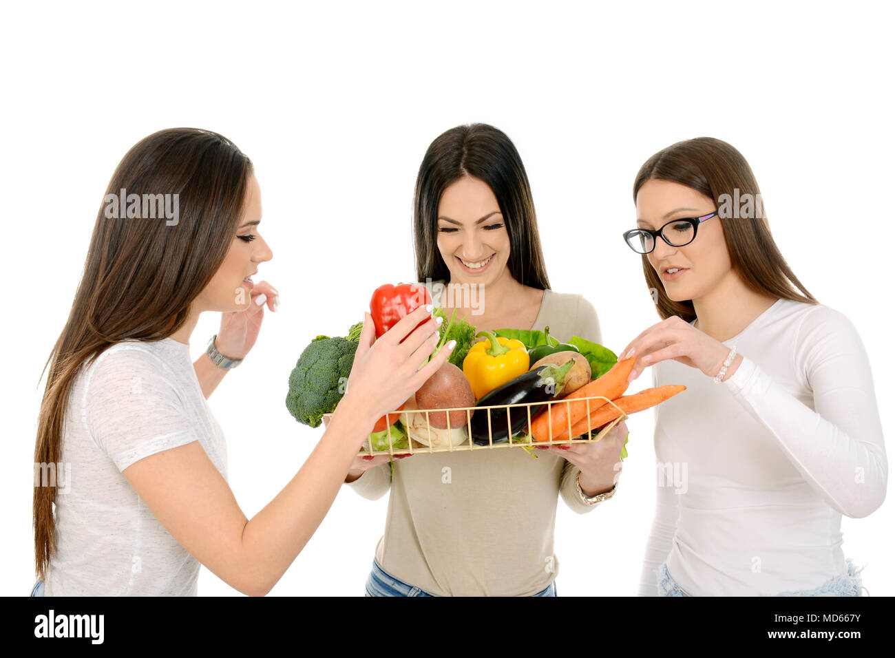Tre belle ragazze azienda cesta piena di verdure miste Foto Stock