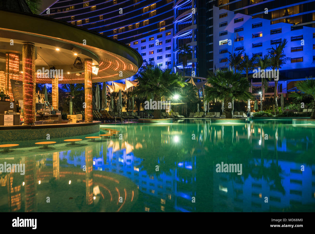 La piscina e il bar al Jumeirah Beach Hotel di notte a Dubai, UAE, Medio Oriente. Foto Stock