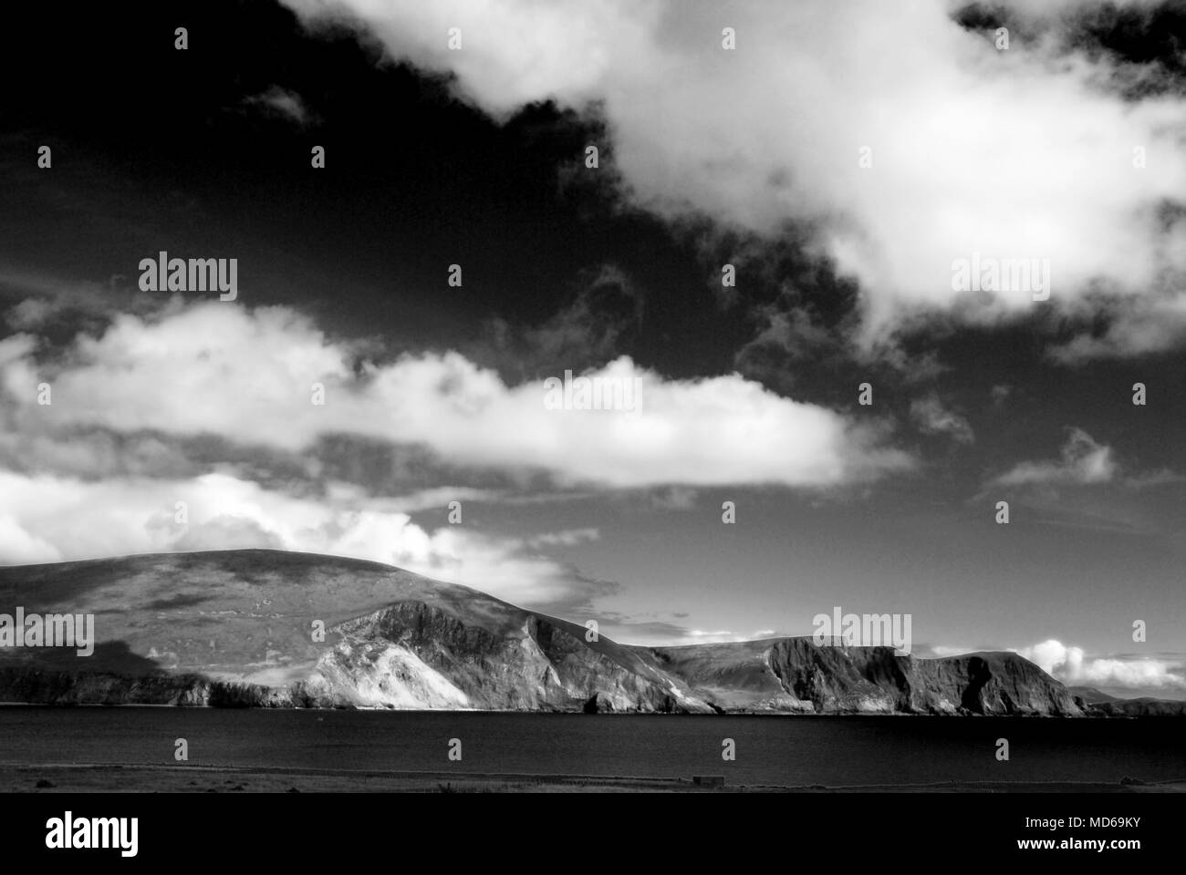 Vista la westcoast di Irlanda in bianco e nero con cieli bui e nuvole bianche flottante tramite Foto Stock