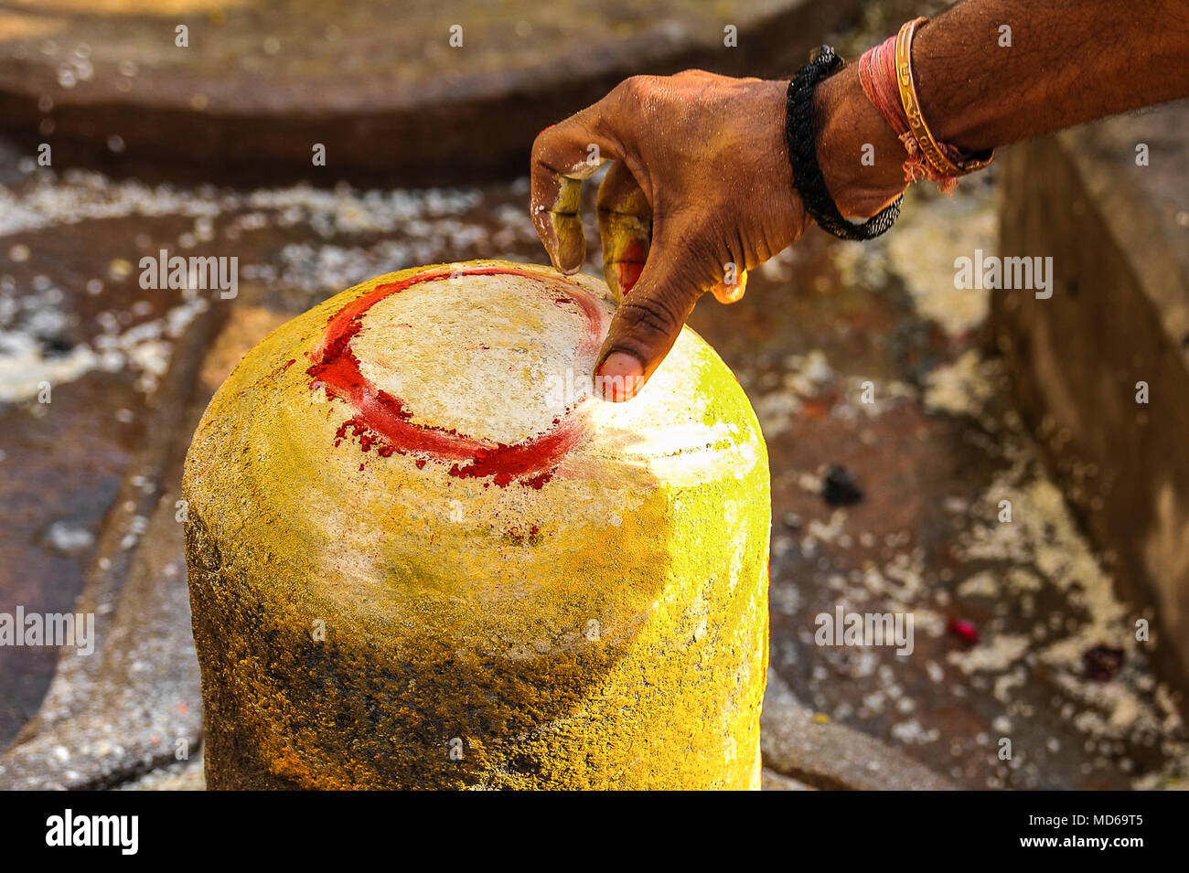 Una mano d'uomo decora un Shiva lingum sul Maha Shivaratri (3/3) Foto Stock
