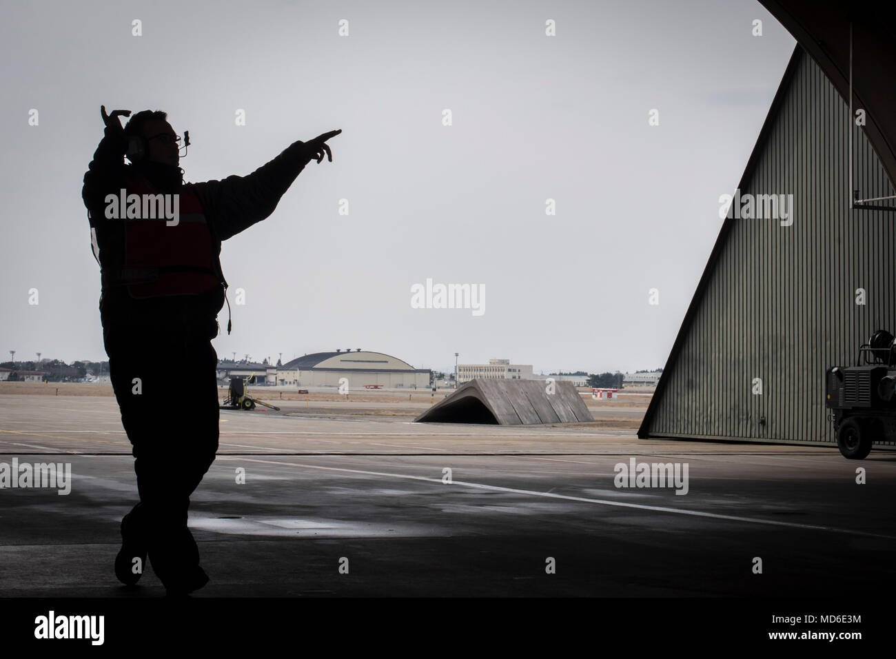 Stati Uniti Air Force Senior Airman Cody Duplaga, un trentacinquesimo Manutenzione aeromobili squadrone capo equipaggio, esegue il marshalling di un F-16 Fighting Falcon a Misawa combatté Air Base, Giappone, 20 marzo 2018. Il dovere di un marshaller è alla guida di un pilota in una posizione di parcheggio in modo sicuro utilizzando la comunicazione visiva tramite i segnali del corpo. (U.S. Air Force foto di Airman Xiomara M. Martinez) Foto Stock