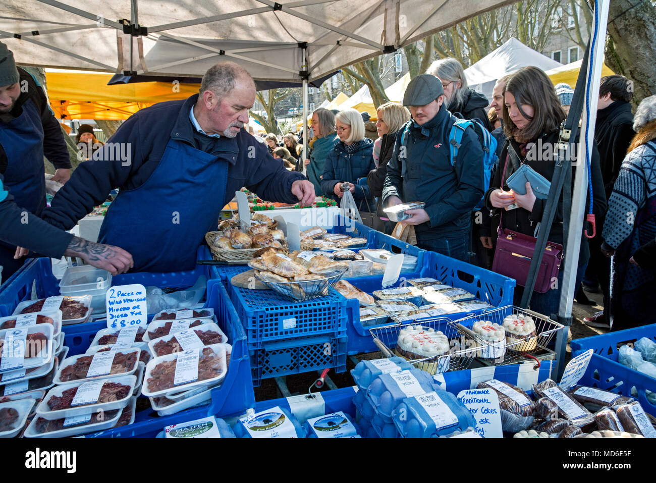 I clienti a base di pesce e selvaggina stallo a Stockbridge mercato domenicale di Edimburgo. Foto Stock