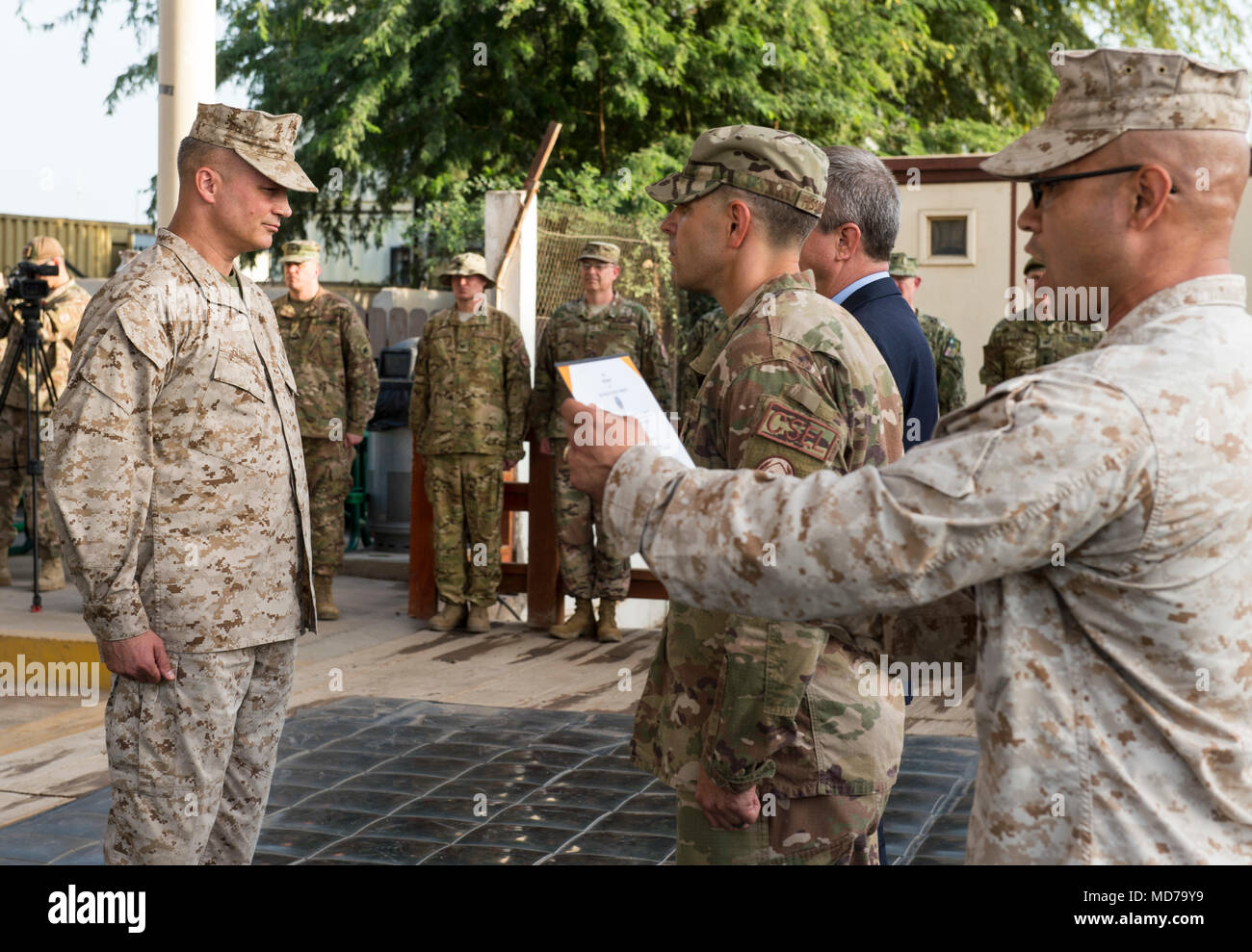 Stati Uniti Marine Corps Capt. Richard Sierra, destra, Combined Joint Task Force - Corno d Africa (CJTF-HOA) aiutante di campo, legge l'ordine la promozione di Brig. Gen. David Furness, sinistra, Comandante generale di CJTF-HOA, al rango di maggiore generale presso il Camp Lemonnier, Gibuti, Marzo 24, 2018. Come il comandante, Furness supervisiona il comando gli sforzi nella lotta contro l'estremismo violento in Africa orientale, la promozione della cooperazione regionale la cooperazione in materia di sicurezza, rafforzamento della nazione partner la capacità di difesa e la costruzione e il mantenimento degli Stati Uniti accesso strategica nella regione. (U.S. Air Force photo by Staff Sgt. Timothy Moore) Foto Stock