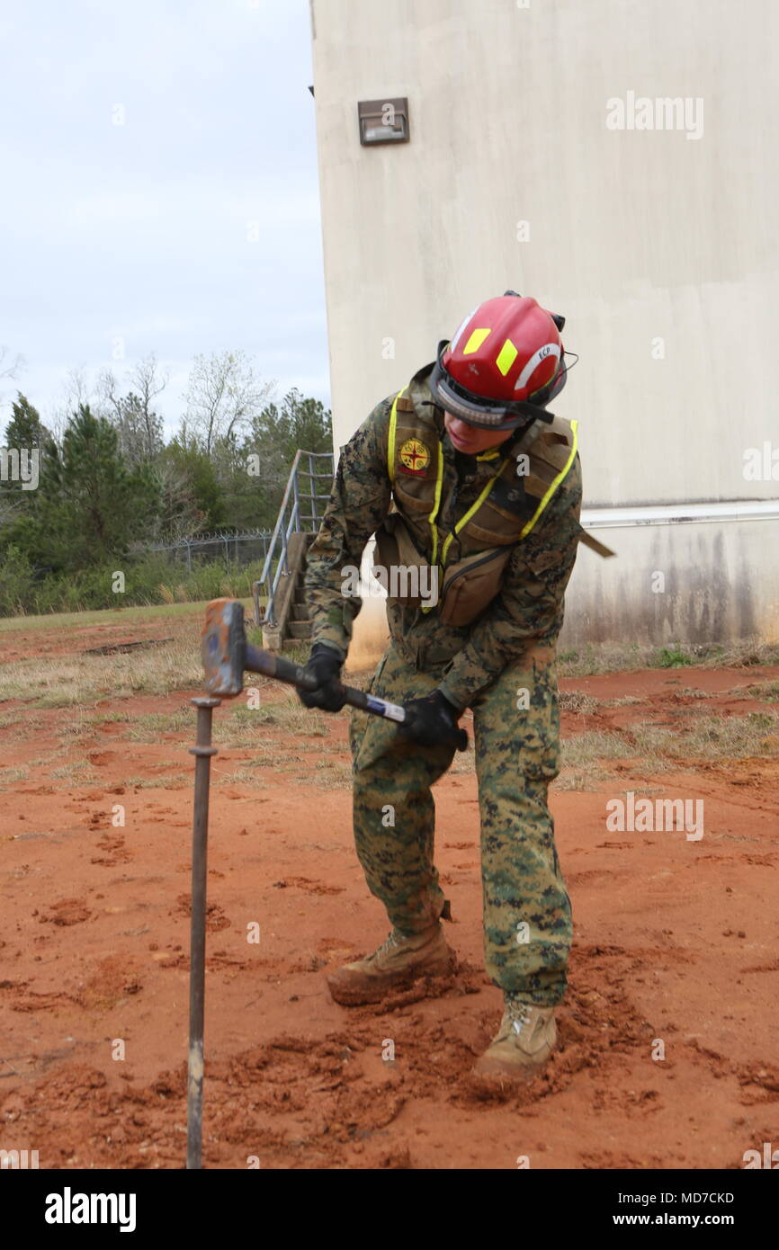 Lancia Cpl. Kenneth McDonald, un estratto Marine con la ricerca e l'estrazione del plotone, Chimica Biologica risposta incidente vigore, martelli un post nel terreno per legare un tutore per trincea collassato al custode centri, Perry, Ga., il 12 marzo 2018. Esercizio Scarlet risposta è uno scenario-based training evoluzione che consente una forza di reazione e di società di sede e di servizio Società Marines e marinai di cross-treno in tutti CBIRF la funzionalità durante due giorni di formazione di corsia e di 12 ore di funzionamento continuo esercizio e un finale di 72 ore di esercizio di certificazione che simula una risposta t Foto Stock