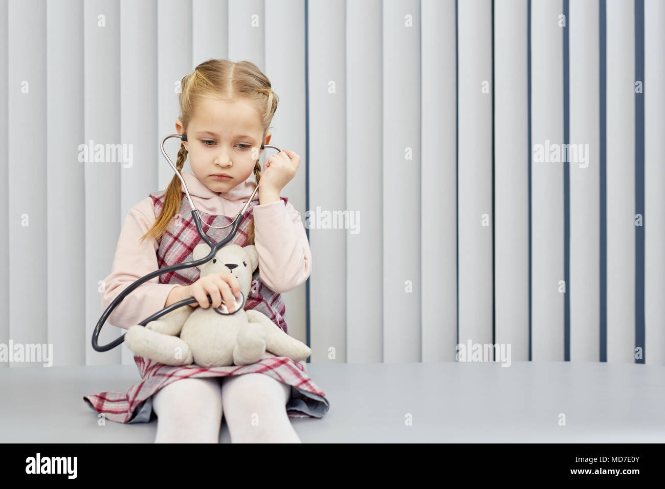Bambina giocando in medico con il suo orsacchiotto Foto Stock