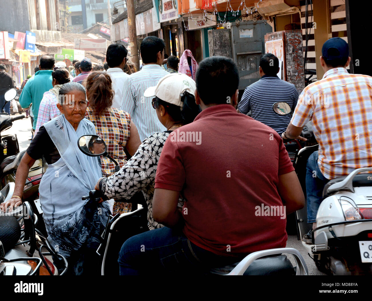 Old Lady determinata a rendere il suo modo attraverso una folla tutti andando nella direzione opposta in una strada di Mumbai, India Foto Stock