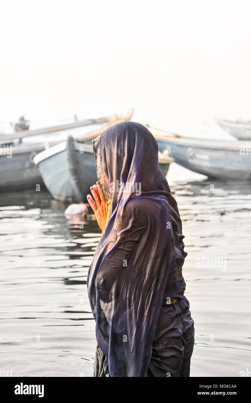 Una donna bagna e prega in il gange Foto Stock