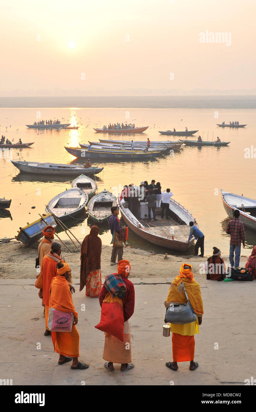 Un gruppo di 'Sadhus' attendere per imbarcazioni turistiche per arrivare a Manmandir ghat di Varanasi Foto Stock