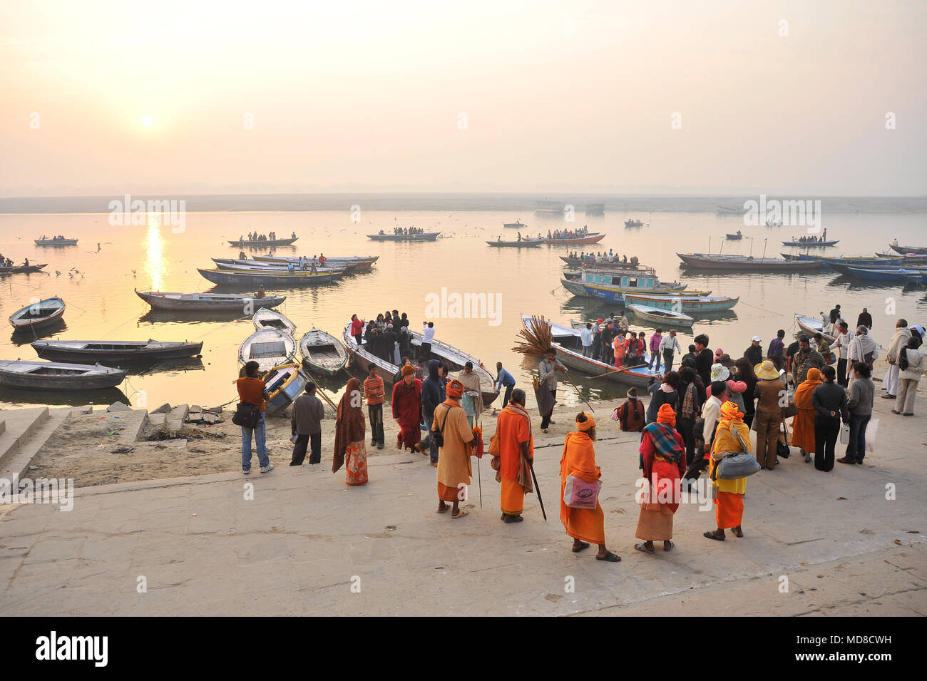 Un gruppo di 'Sadhus' attendere per imbarcazioni turistiche per arrivare a Manmandir ghat di Varanasi Foto Stock