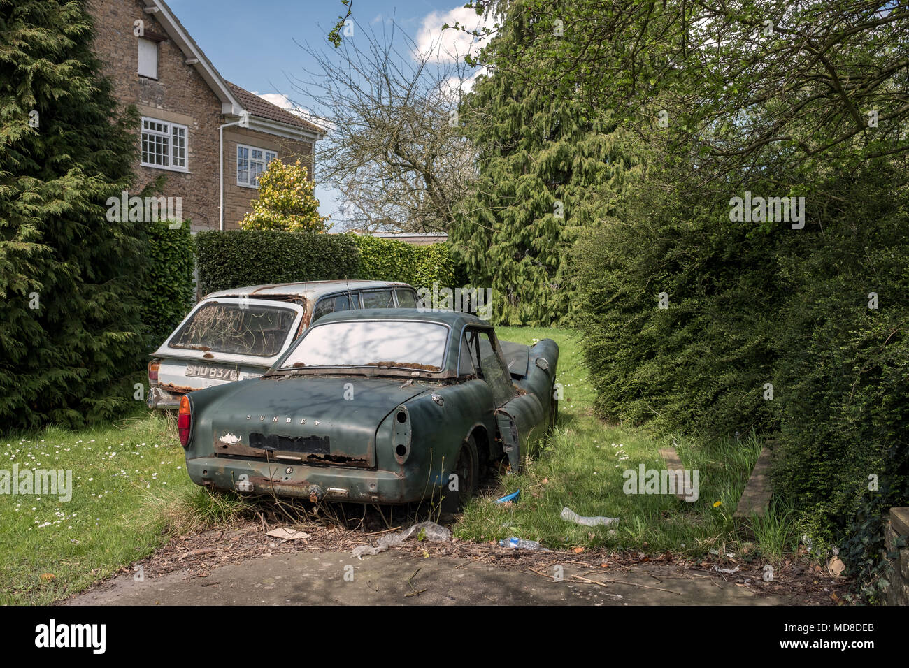 Aprile 2018 - vecchie automobili inglesi dolcemente arrugginimento lontano in un giardino Foto Stock