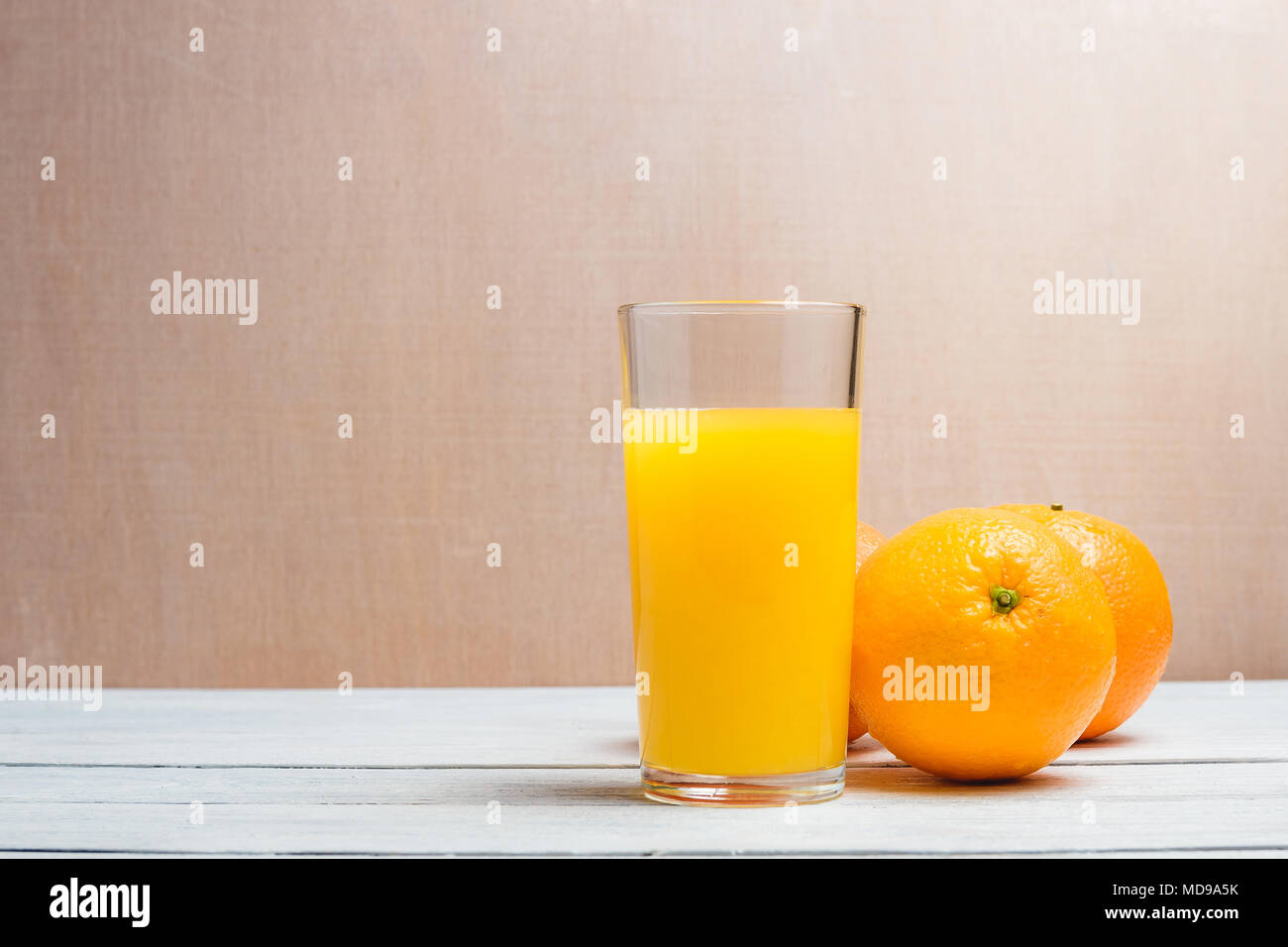 Fette di arancia e bere succo di frutta bianca su sfondo di legno. Un sano concetto con Copyspace. Foto Stock