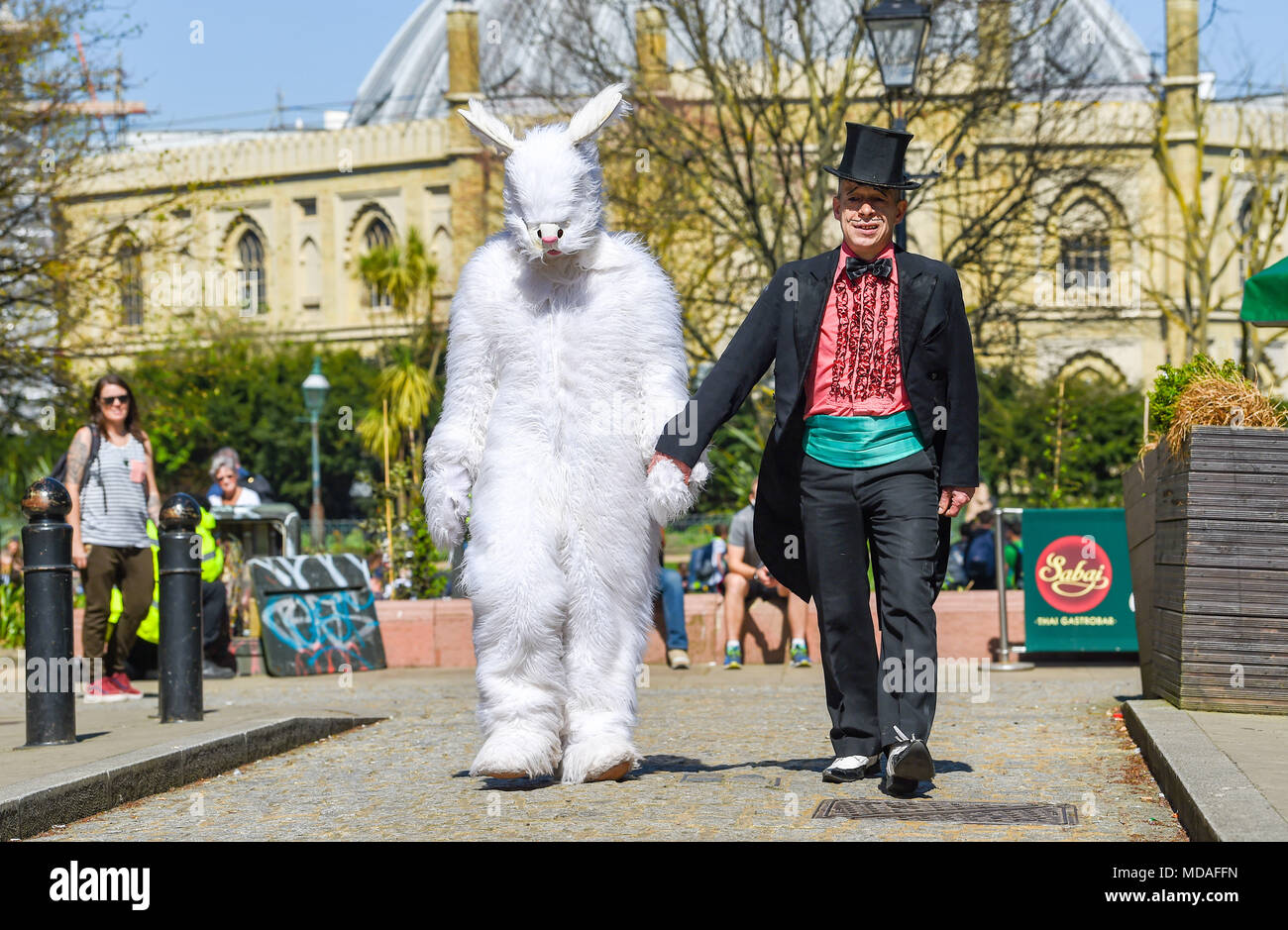 Brighton Regno Unito 19 aprile 2018 - tempo caldo per una passeggiata con un coniglio gigante nel centro città di Brighton oggi . Essi fanno parte del Duo Bogof arte magica che si esibirà al Brighton Fringe nel maggio . Il caldo clima soleggiato è impostata per continuare in tutta la Gran Bretagna con temperature attese per raggiungere l'alta venti in alcune parti del Sud Est Credito: Simon Dack/Alamy Live News Foto Stock