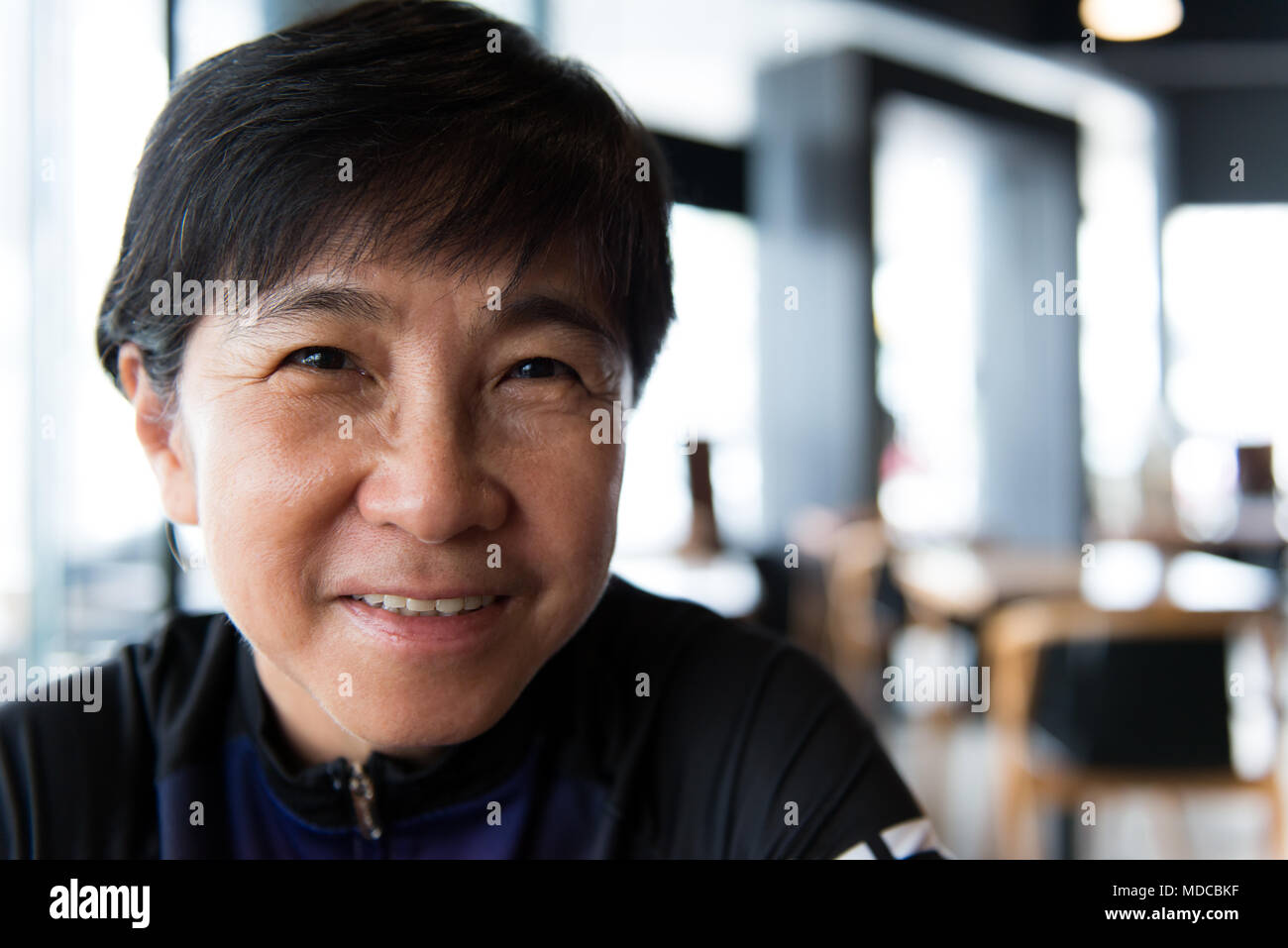 Senior donna asiatica con caffè nel ciclismo jersey Foto Stock