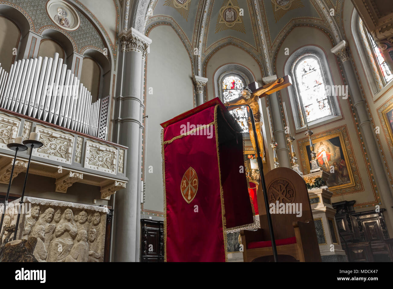 Chiesa cattolica interni. Sull'altare un crocifisso e un rosso parament liturgico. Foto Stock