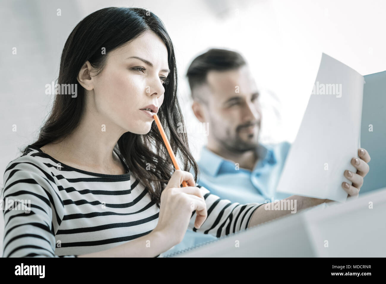 Attento serio donna cerca attraverso il documento Foto Stock