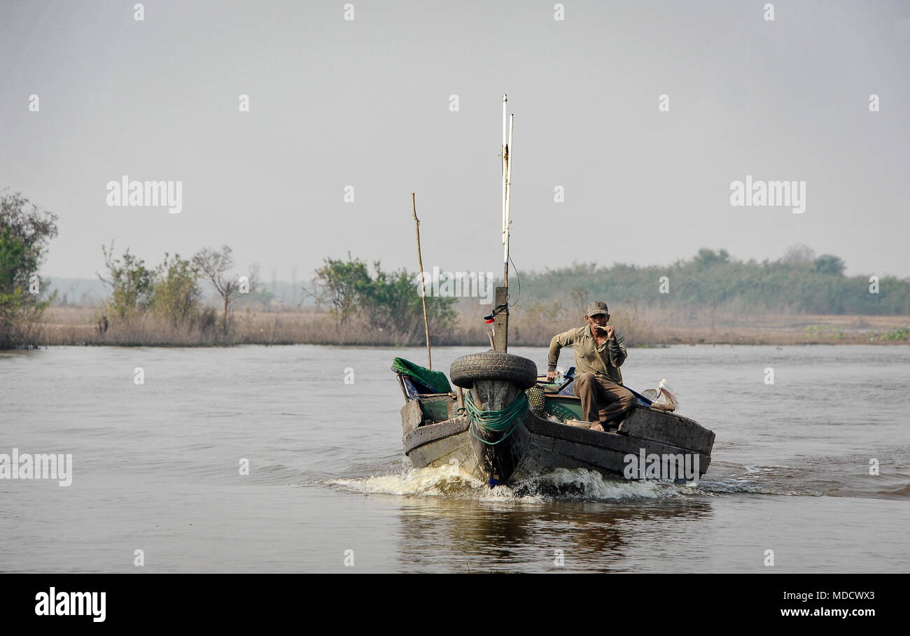 Il fiume Tonle Sap, Cambogia: un pescatore locale manzi la sua barca a monte in un paesaggio rurale Foto Stock