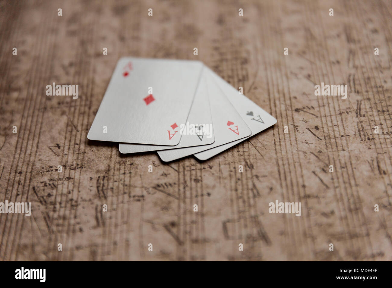 Quattro Assi carte da gioco su un vecchio foglio musicale Foto Stock