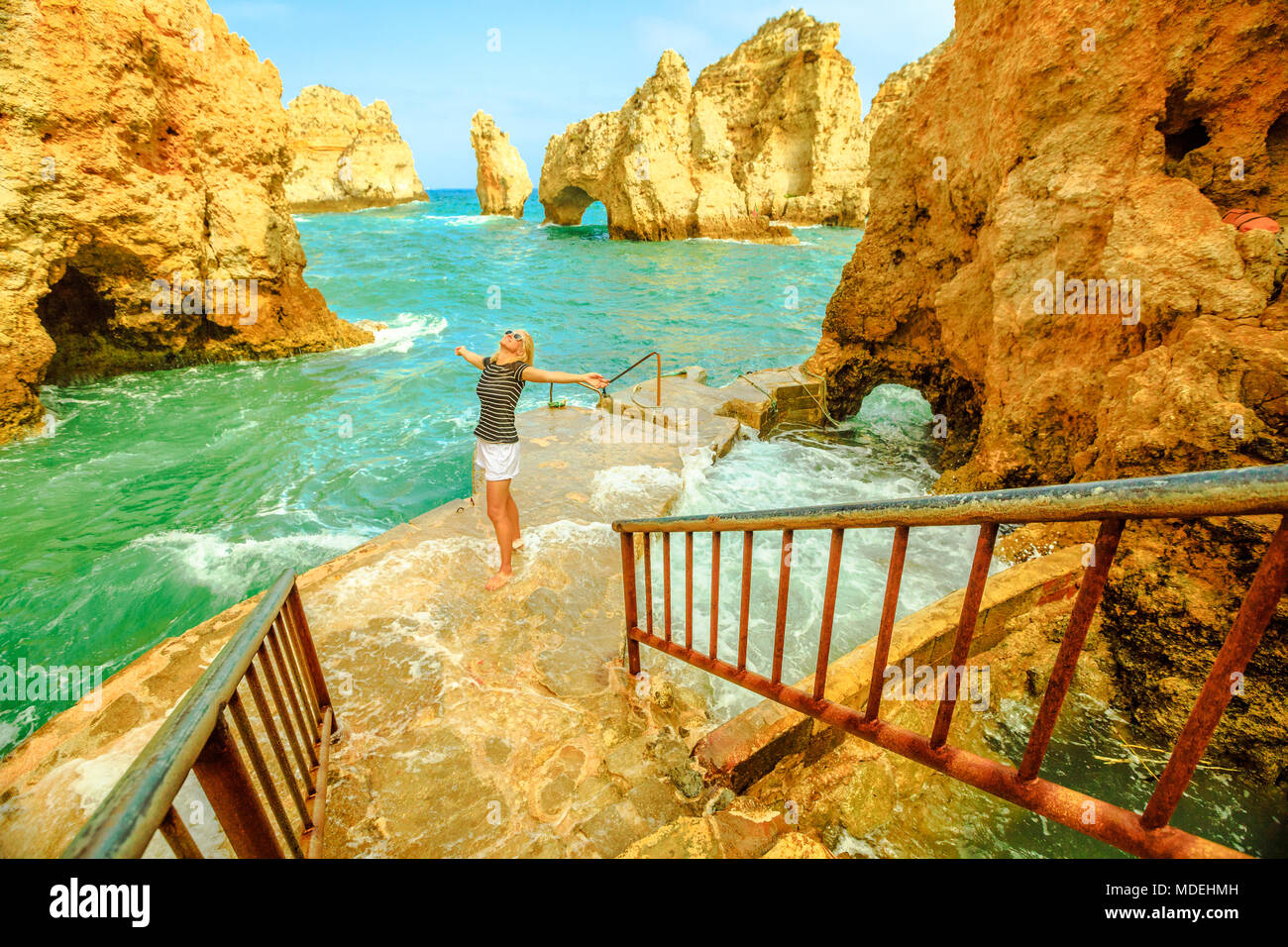 Alla fine della scalinata che conduce Ponta da Piedade. Il molo per piccole imbarcazioni per escursioni turistiche tra archi e grotte naturali. Libertà lifestyle tourist godendo di Lagos, Algarve, Portogallo. Vento e onde Foto Stock