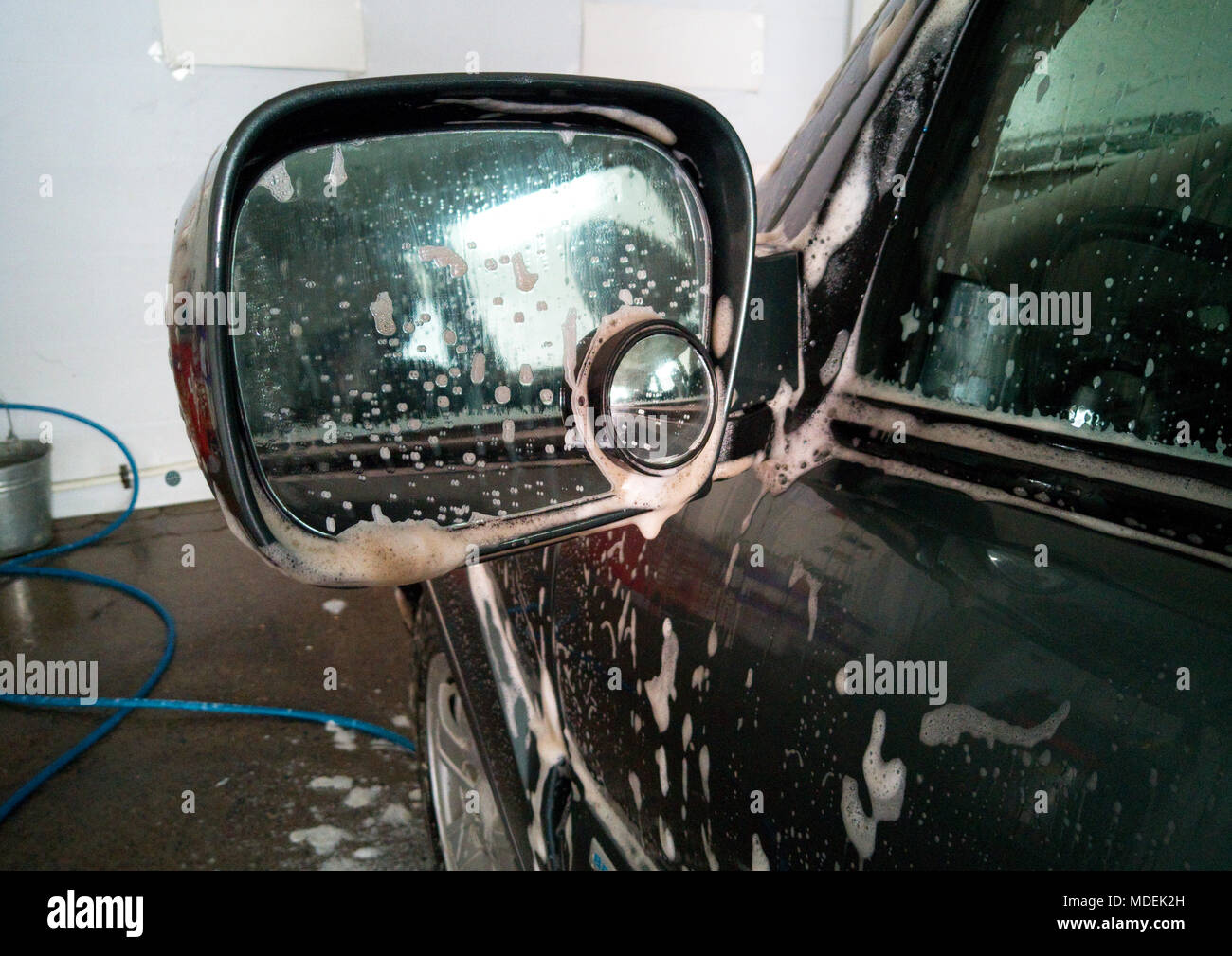 Car Wash. Schiuma di sapone sporco asportato dal lato dello specchio Foto Stock