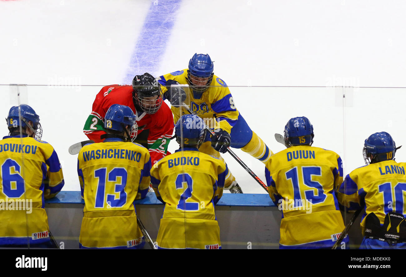Kiev, Ucraina - 17 Aprile 2018: Ucraino giocatori su banco guarda mentre L.KERESZTES di Ungheria (L) si batte per un puck con B.SEREDNITSKYY dell'Ucraina Foto Stock