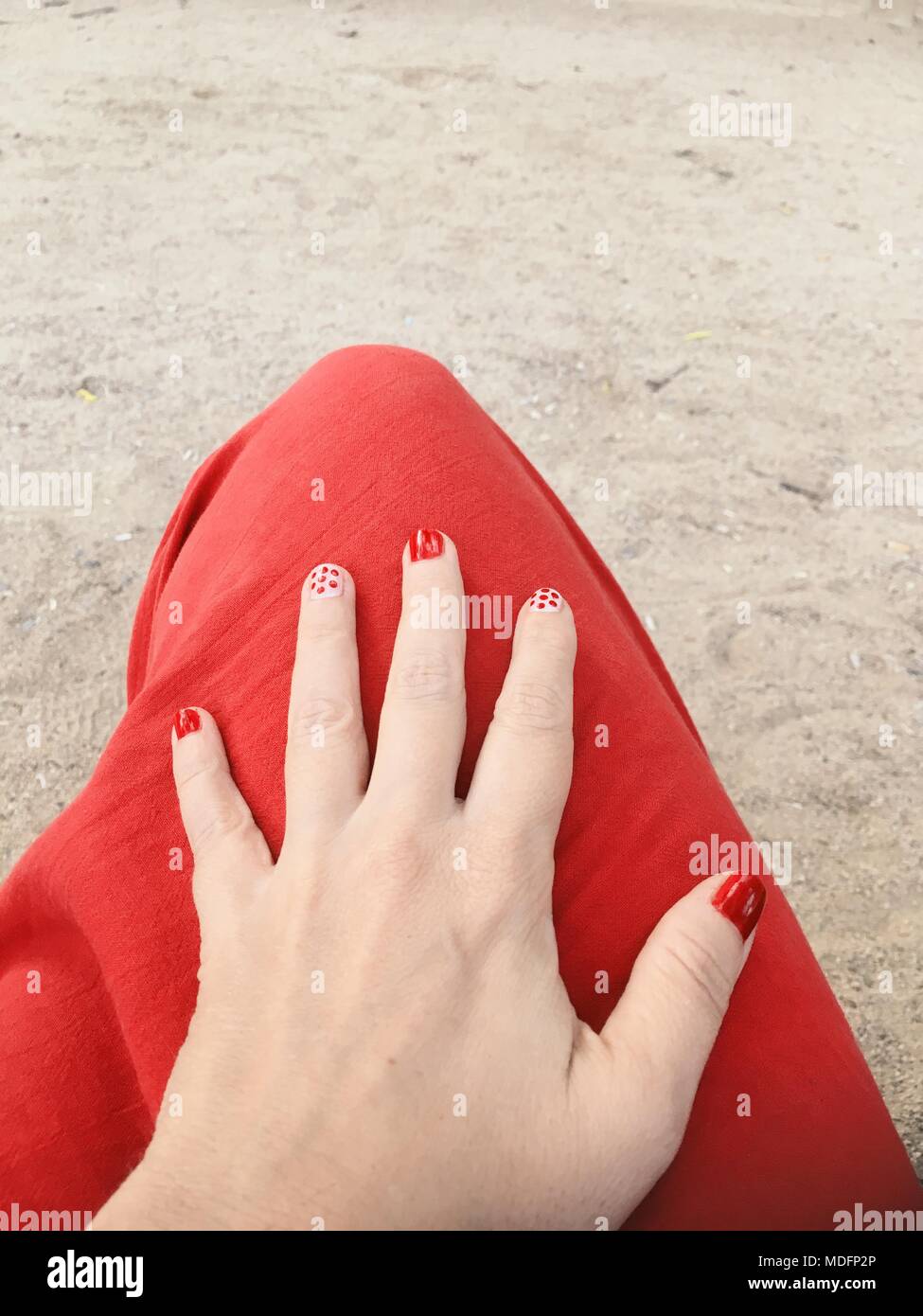 Donna di mano sul ginocchio con la Nail art Foto Stock