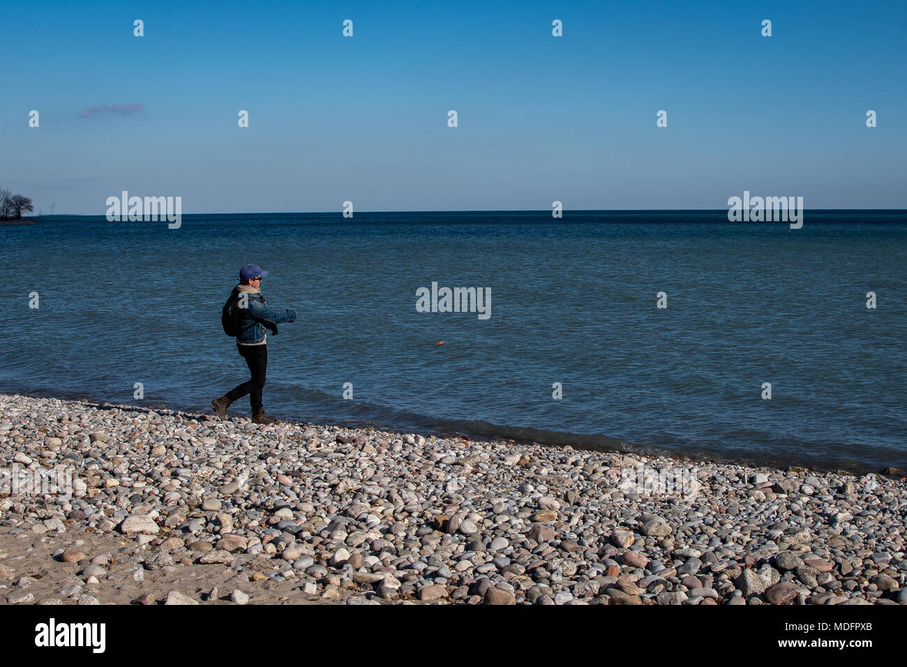 Uomo a camminare lungo la spiaggia Foto Stock