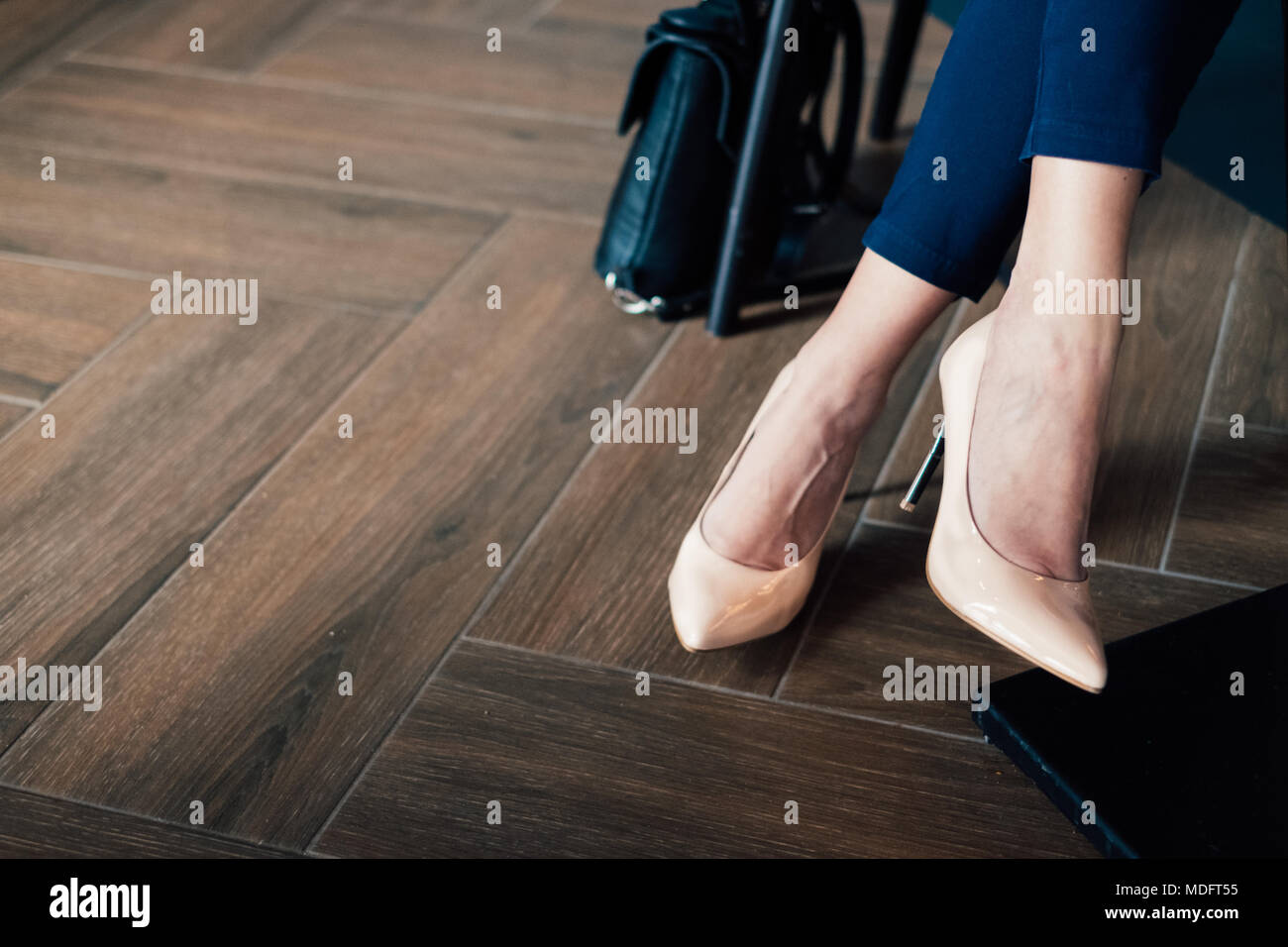 Close-up di imprenditrice per le gambe in un pantalone di tuta e stiletto guarisce Foto Stock