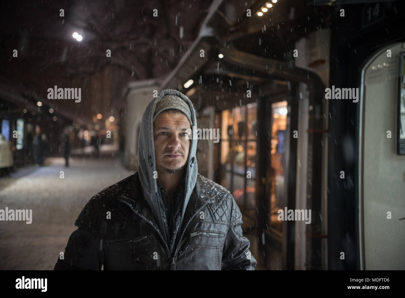 Ritratto di un uomo a piedi attraverso la città nella neve Foto Stock