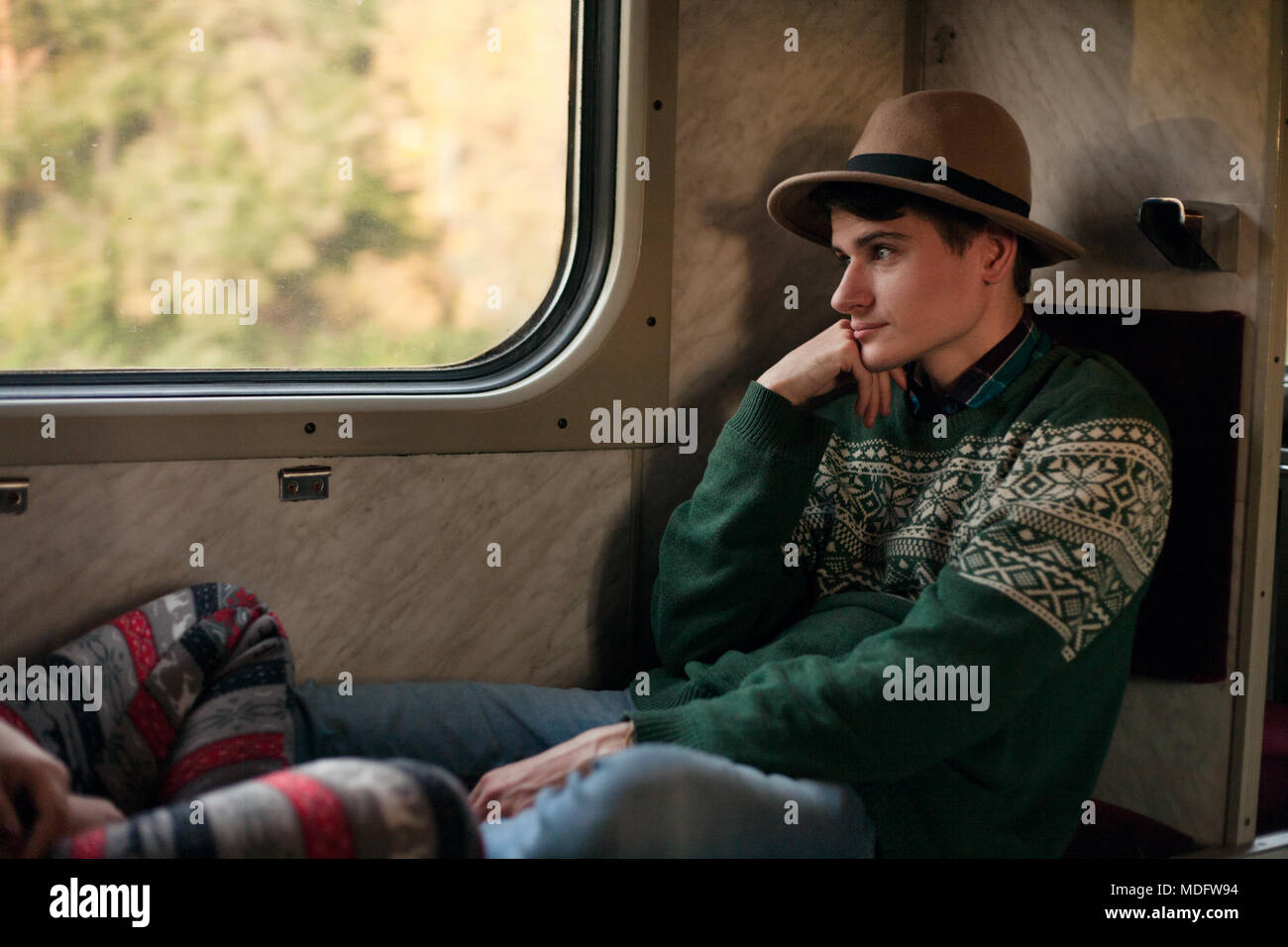 Giovane uomo seduto su un treno Foto Stock