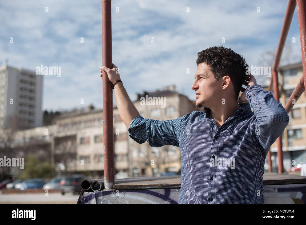 Ritratto di un uomo in città con la sua mano i suoi capelli Foto Stock