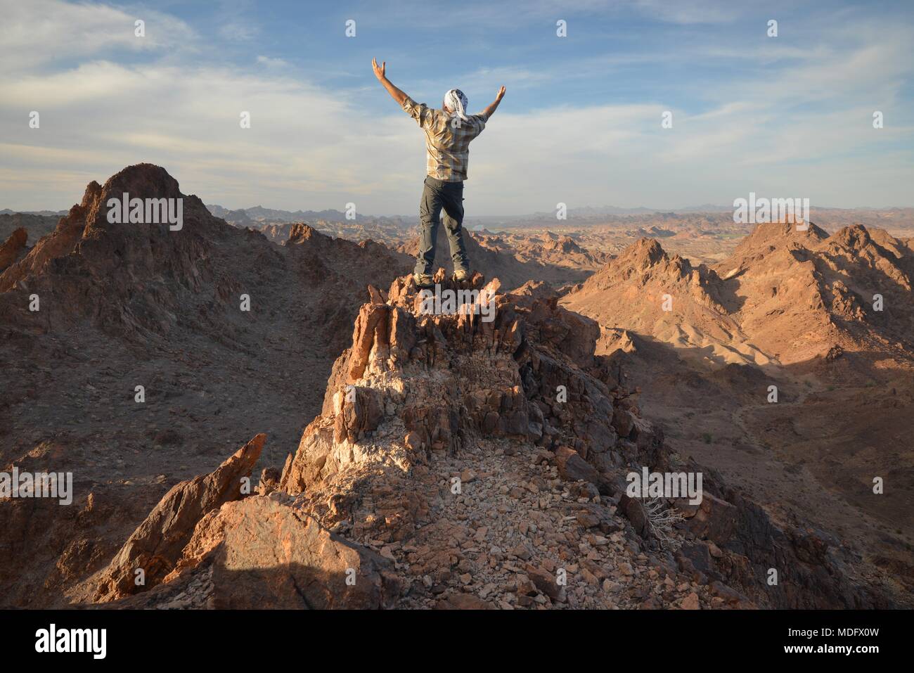 Uomo in piedi sulla cima della montagna con le sue braccia distese, Indian Pass Wilderness, California, Stati Uniti Foto Stock