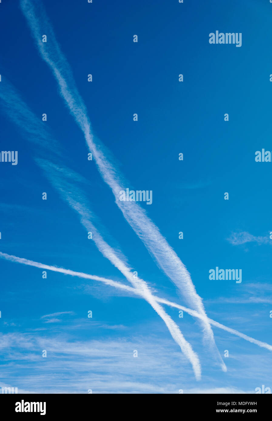 Jet bianco contrails contro un cristallo azzurro cielo azzurro Foto Stock