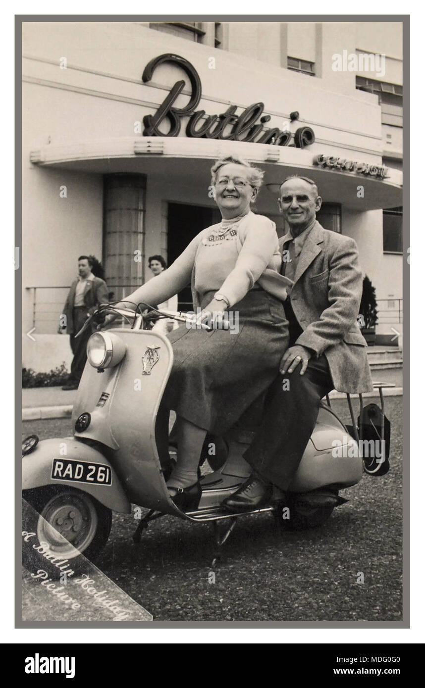 Anni Cinquanta Vintage Butlin ufficiale della vacanza fotografia di un post guerra felice coppia matura a cavallo di una (dell'epoca) trendy Lambretta scooter, con la Butlin's Ocean Hotel dietro, Saltdean East Sussex Regno Unito Foto Stock