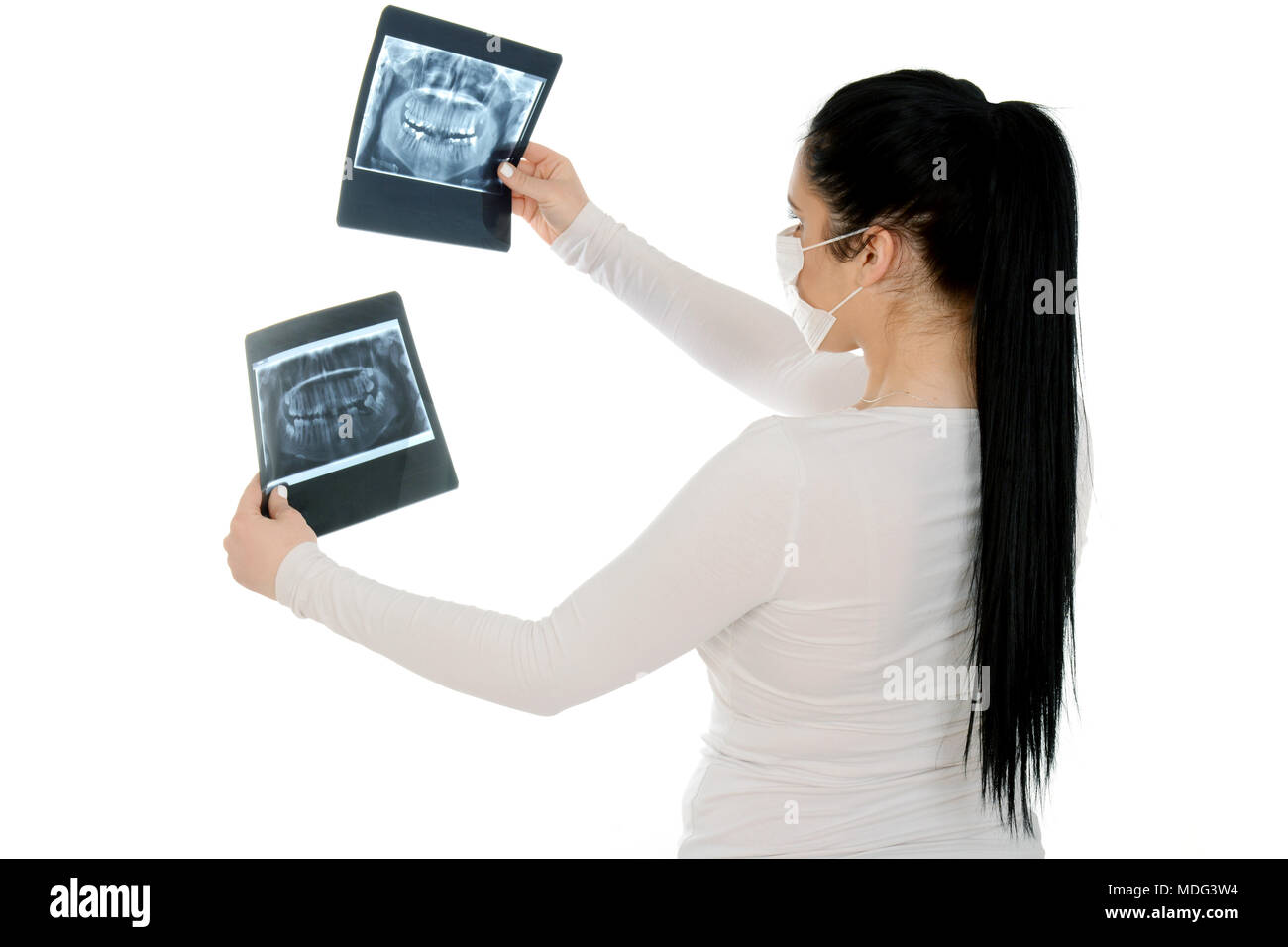 Raggi X di una mandibola umana nelle mani del dentista. Bella ragazza tenendo premuto x-ray, indossare la maschera protettiva. Foto Stock