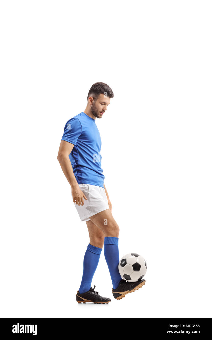 Lunghezza piena ripresa di profilo di un giocatore di calcio La giocoleria un calcio isolati su sfondo bianco Foto Stock