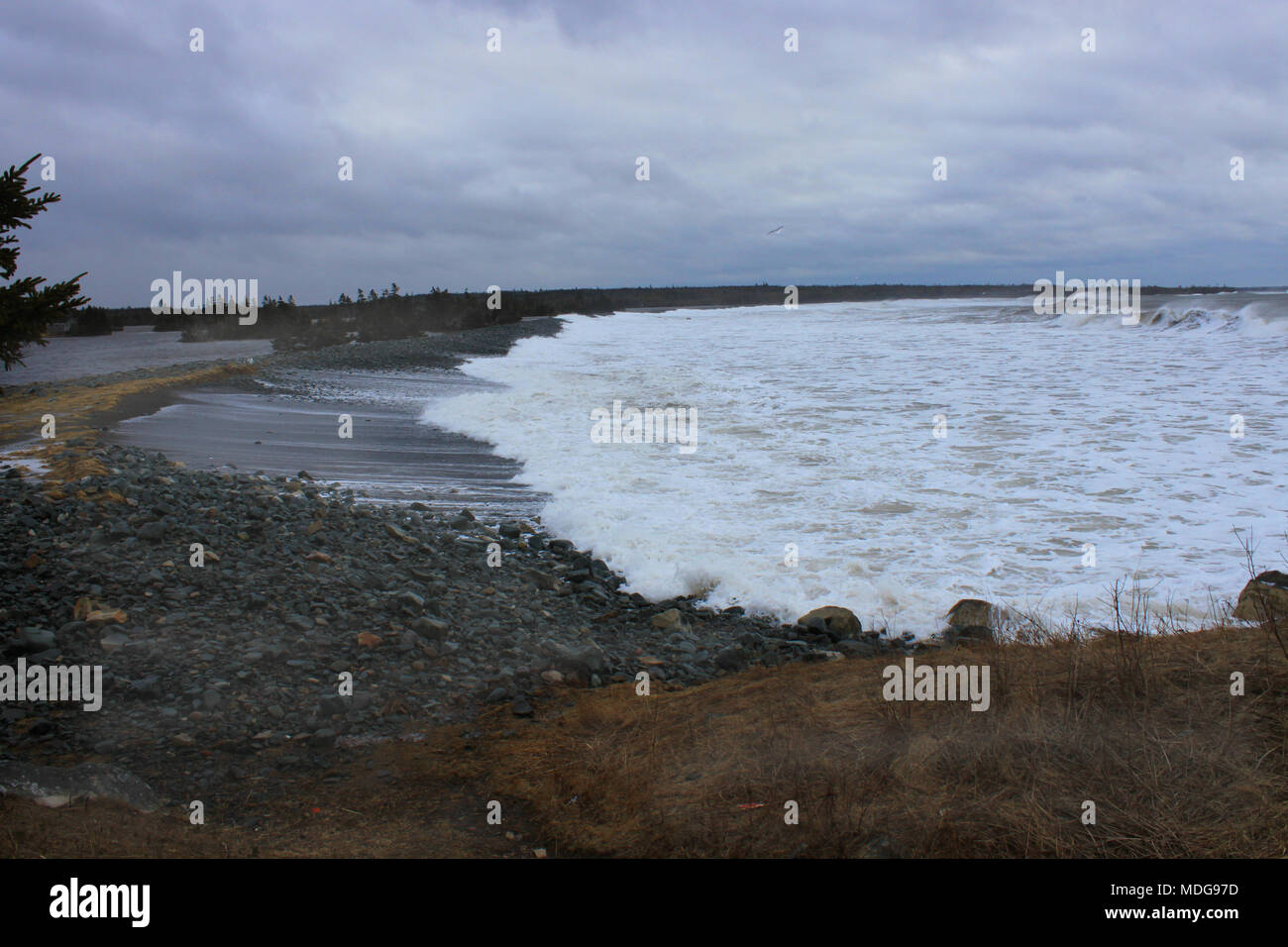 Le onde di violare la barriera e riversandosi nel lago Grande a Long Beach, Lower East Chezzetcook, Nova Scotia, Canada Foto Stock