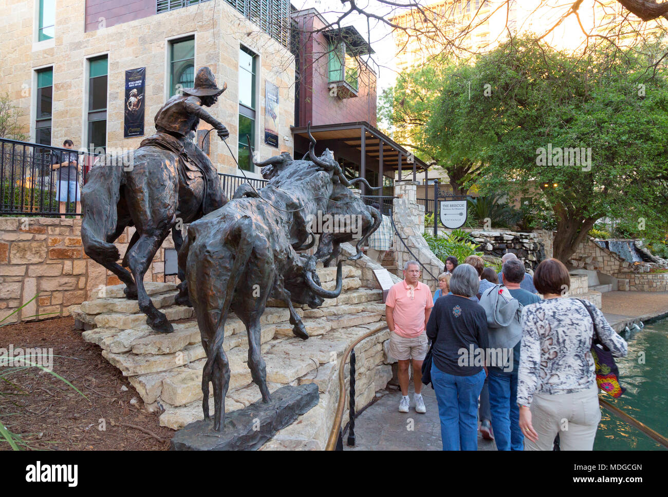 Turisti e D.T. Kelsey's "arriva a casa per la Briscoe" scultura al di fuori del Briscoe Western Art Museum, il lungofiume di San Antonio, Texas, Stati Uniti d'America Foto Stock