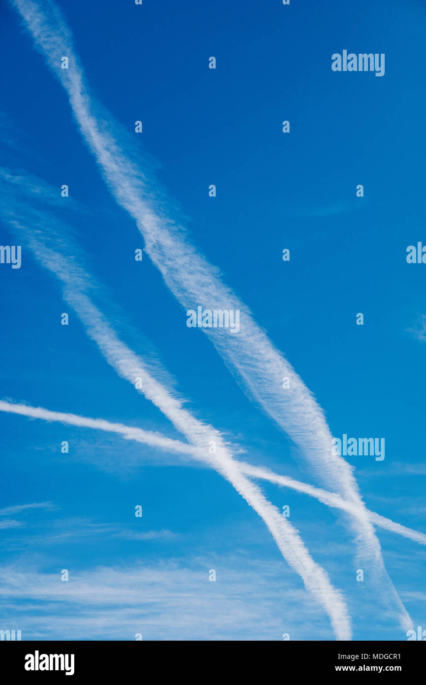 Jet bianco contrails contro un cristallo azzurro cielo azzurro Foto Stock