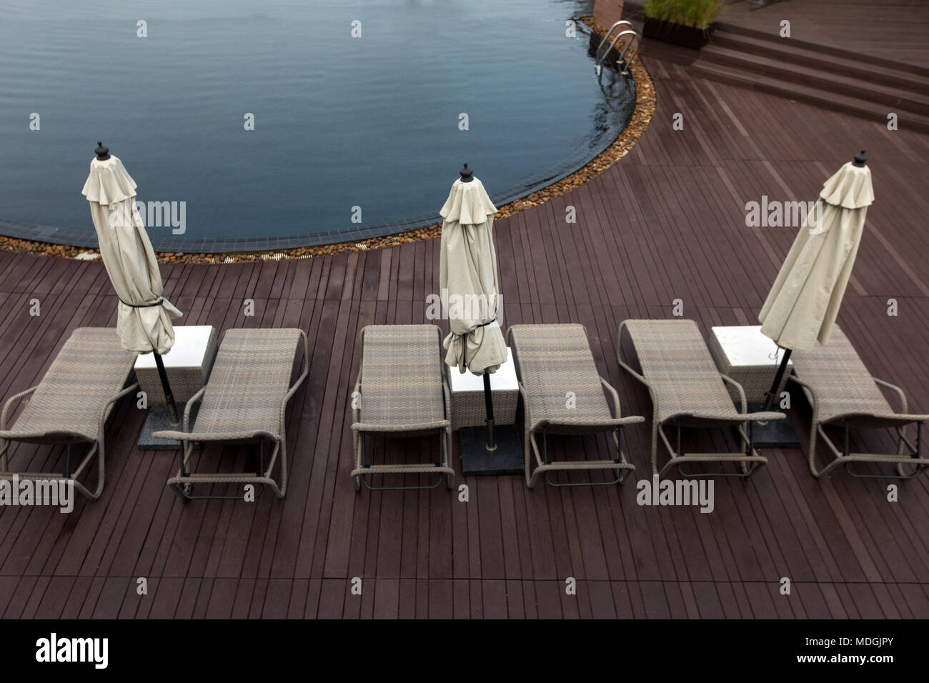 Area piscina con lettini per prendere il sole Foto Stock