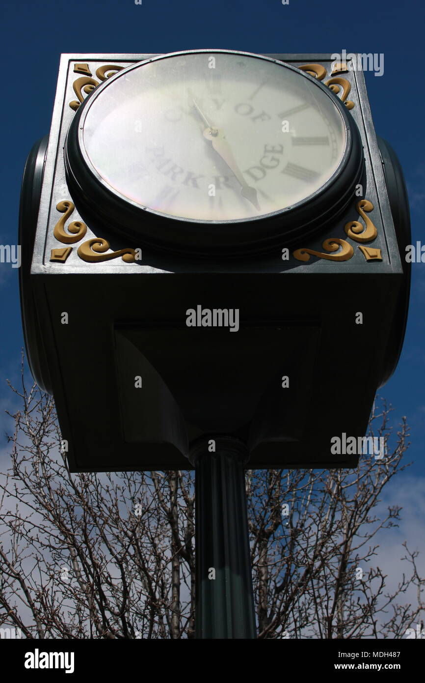 Vista dal basso di un angolo enorme orologio pubblico con un alterato e graffiato pannello. Foto Stock