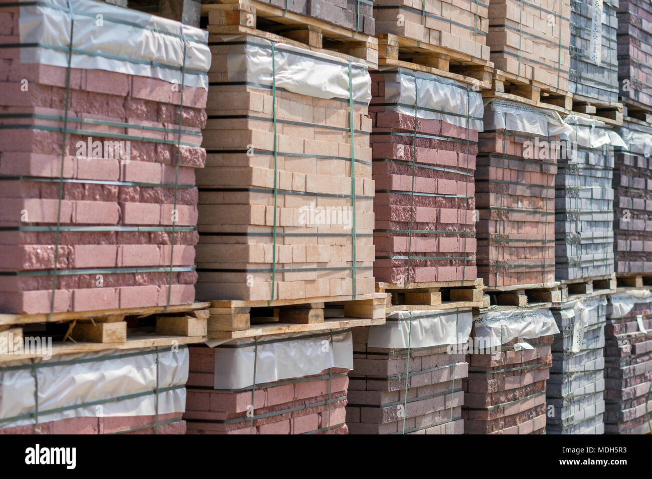 Mattoni di argilla stock di impilamento dei pallet sul sito di costruzione. Materiale consegnato dalla fabbrica Foto Stock