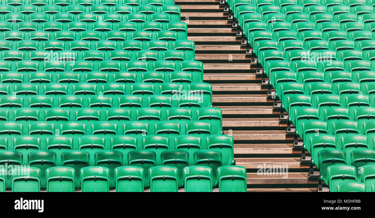 Righe di verde vuoto stadio di piegatura dei sedili e scale in legno Foto Stock