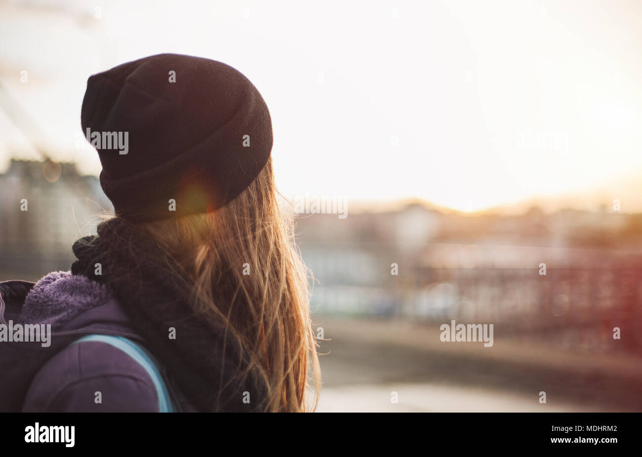 Hipster ragazza camminare sulla strada della citta' al tramonto Foto Stock