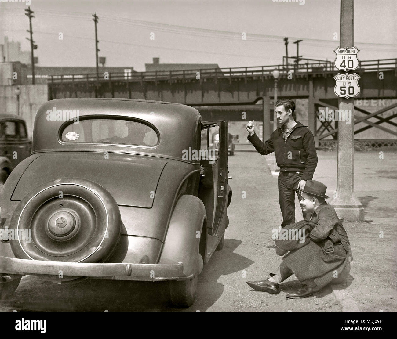 Un misterioso guidatore apre la portiera della macchina per due uomini autostop in Kansas City, Kansas. Immagine da 5x7 pollici fotocamera negativo, circa 1934. Foto Stock