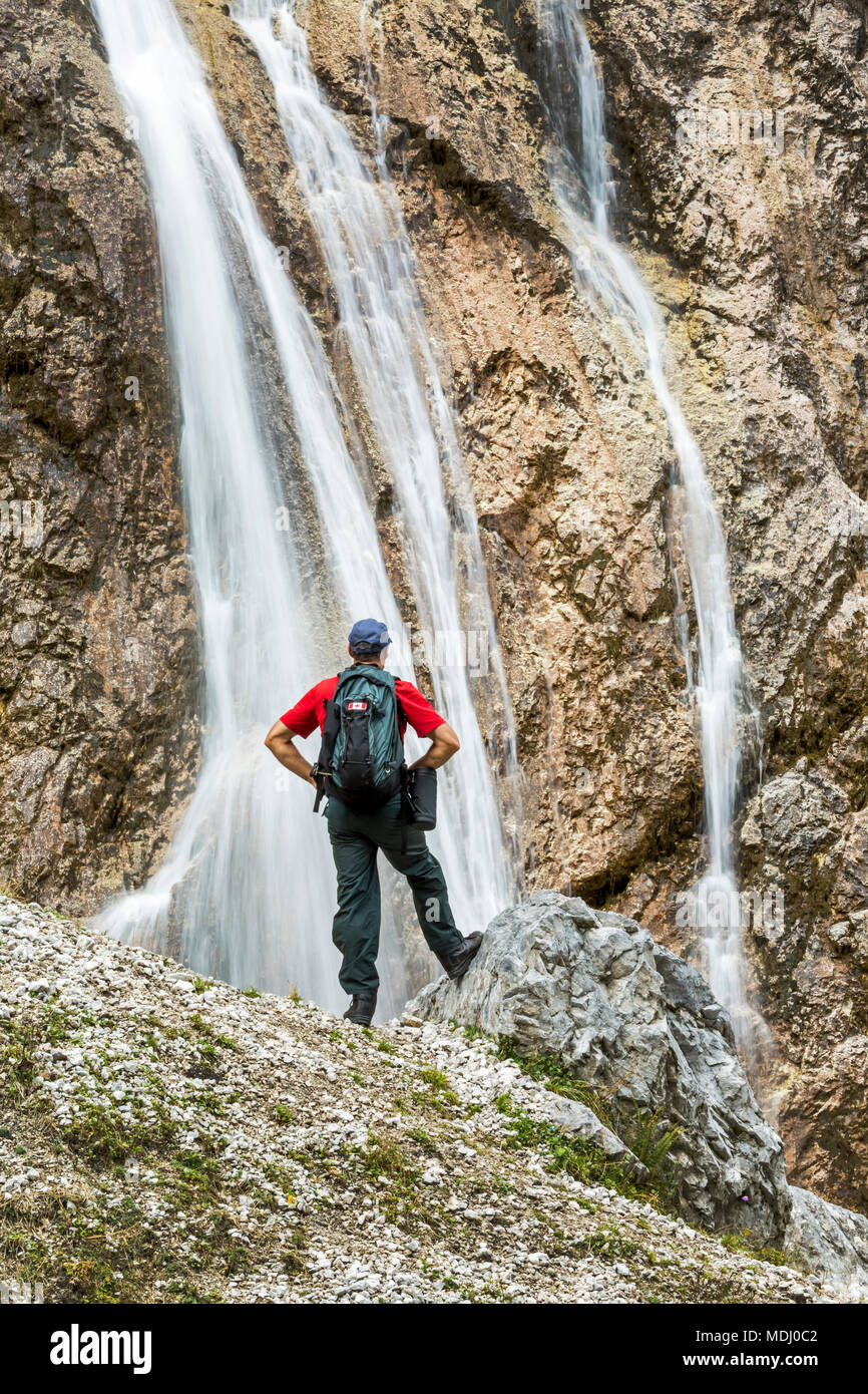 Escursionista maschio sul pendio roccioso affacciato sulla scogliera cascate; Grainau, Baviera, Germania Foto Stock