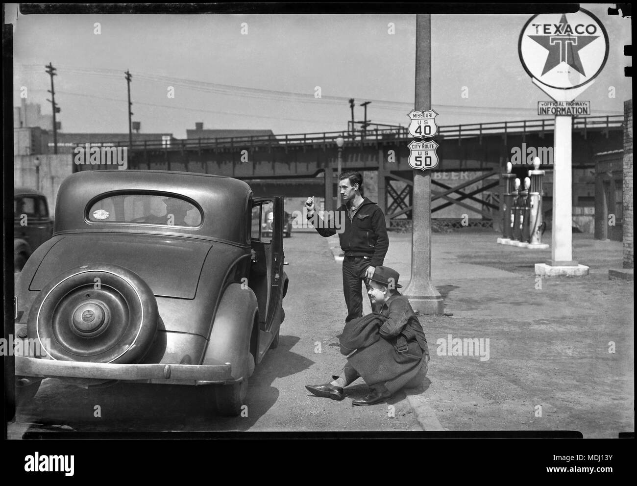 Un misterioso guidatore apre la portiera della macchina per due uomini autostop in Kansas City, Kansas. Immagine da 5x7 pollici fotocamera negativo, circa 1934. Foto Stock
