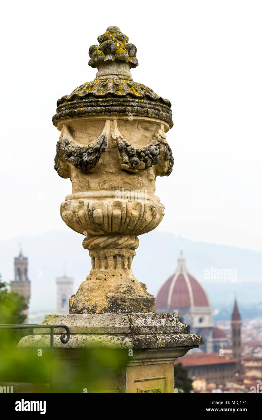 Close-up di urna di pietra sulla sommità della colonna con la cupola del Duomo di Firenze e torri in background; Firenze, Toscana, Italia Foto Stock