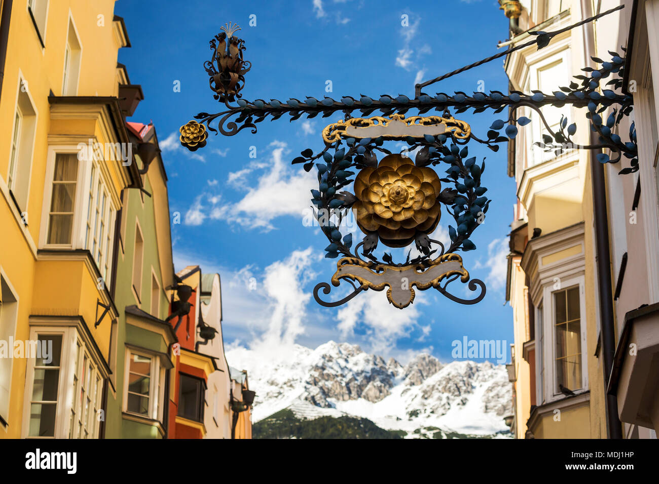 Close-up decorativo di cartello in metallo con montagne coperte di neve e cielo blu in background; Innsbruck in Tirolo, Austria Foto Stock