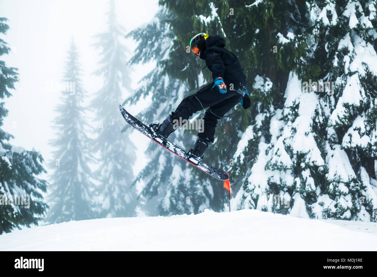 Un ragazzo adolescente lo Snowboard sul Monte Seymore, North Vancouver; Vancouver, British Columbia, Canada Foto Stock